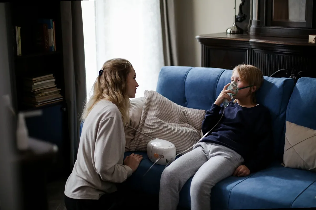Parent giving inhalation therapy to child