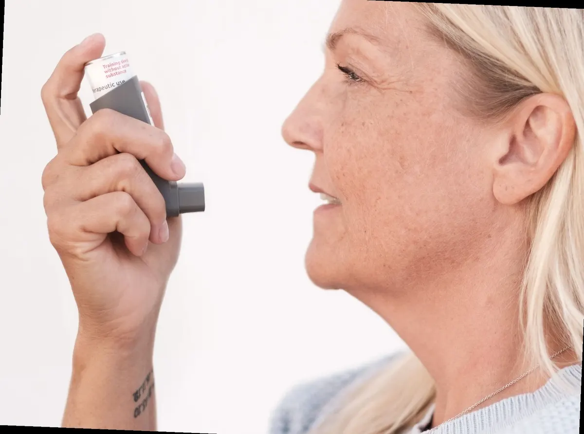 person using asthma inhaler at home