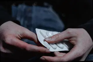 person preparing to take medication tablets